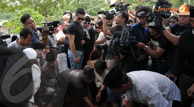 Tangis Jupe pecah saat jenazah ayahnya dikumandangkan adzan sebelum diurug tanah (Liputan6.com/Helmi Fithriansyah)
 