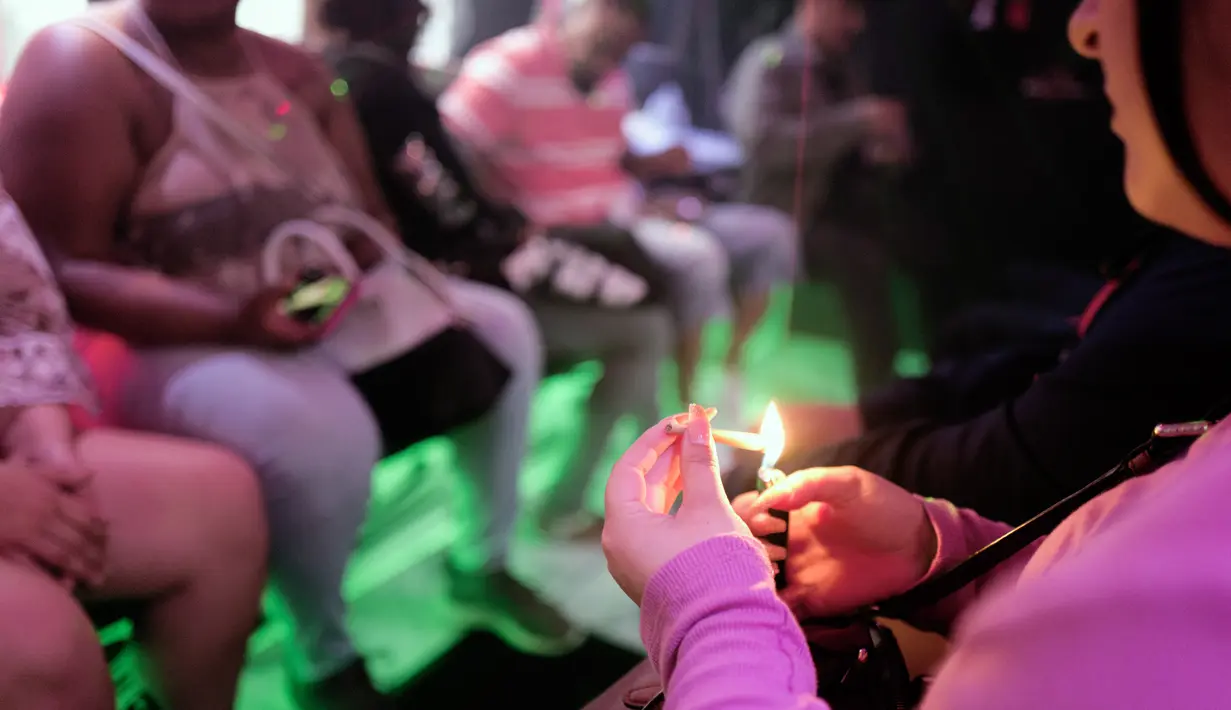 Seorang wisatawan wanita mengisap ganja di dalam bus Green Line Trips di Los Angeles, Amerika Serikat, Sabtu (19/5). Industri ganja California menargetkan wisatawan serta penduduk setempat, tur, toko, penginapan, dan iklan. (AP Photo/Richard Vogel)