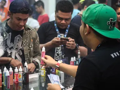 Pecinta Vape atau rokok elektrik sedang mencoba keunggulan alat dan rasa liquid di stand Vape Fair 2016 di Ecovention Hall Ancol, Jakarta, Minggu (27/11). (Liputan6.com/Faizal Fanani)