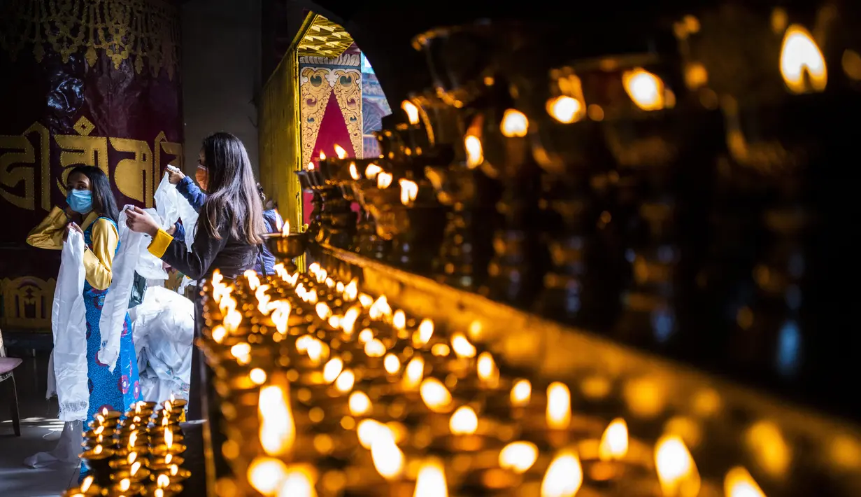 Pengungsi Tibet memasuki sebuah kuil untuk berdoa pada hari pertama Tahun Baru Imlek di New Delhi, India, pada Jumat (12/2/2021). Mengikuti kalender China, Tahun 2021 adalah Tahun Kerbau Logam. (Jewel SAMAD / AFP)