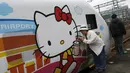 Seorang wanita berpose disamping kereta Taroko Ekspres yang bertemakan Hello Kitty di Taipei, Taiwan, Senin (21/3). Kereta tersebut akan melakukan perjalanan perdananya dari Taipe ke Taitung. (REUTERS/Tyrone Siu)