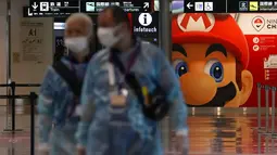 Petugas medis berjalan sambil menunggu kedatangan penumpang di Bandara Internasional Narita, Tokyo, Kamis (15/7/2021). Penyelenggaraan Olimpiade Tokyo akan didadakan di bawah keadaan darurat covid-19 yang diumumkan di Ibu Kota Jepang. (AP Photo/Kiichiro Sato)