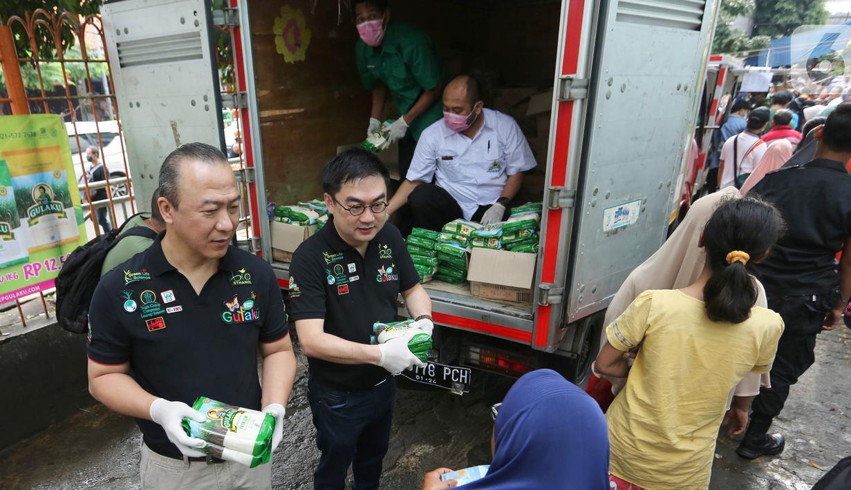 Direktur Sugar Group Companies Yusuf Sumartha dan Irwan Ang memberikan gula pasir kepada warga saat Operasi Pasar di Pasar Palmerah, Jakarta, Jumat (20/3/2020). Sugar Group Companies menjamin ketersediaan gula selama satu di 35 titik pasar wilayah DKI Jakarta dan Banten. (Liputan6.com/Fery Pradolo)
