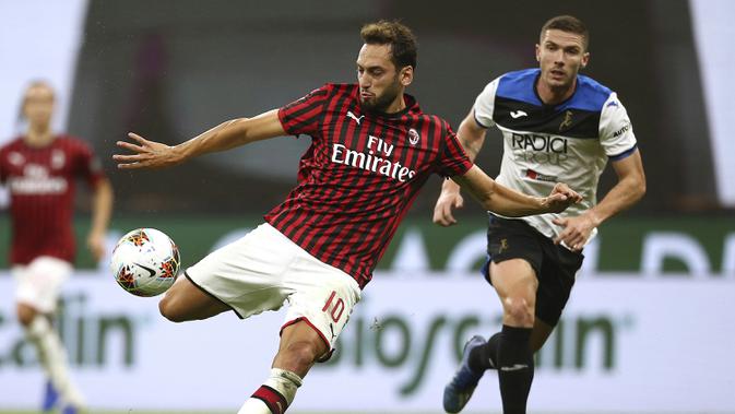 Gelandang AC Milan, Hakan Calhanoglu, melepaskan tendangan ke arah gawang Atalanta pada laga lanjutan Serie A di Stadion San Siro, Sabtu (25/7/2020) dini hari WIB. AC Milan bermain imbang 1-1 atas Atalanta. (Spada/LaPresse via AP)