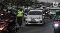 Petugas kepolisian memberhentikan mobil yang melanggar aturan ganjil genap di Jalan MT Haryono, Jakarta, Kamis (28/10/2021). Direktorat Lalu Lintas Polda Metro Jaya mulai hari ini memberlakukan sanksi tilang kepada pelanggar ganjil genap di 13 ruas jalan DKI Jakarta. (merdeka.com/Iqbal S Nugroho)