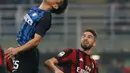 Pemain Inter Milan, Yuto Nagatomo menyundul bola di depan pemain AC Milan, Fabio Borini pada pekan kedelapan Liga Italia di Stadion Giuseppe Meazza, Minggu (15/10). Gol Inter Milan diborong oleh Mauro Icardi, 3-2. (AP/Antonio Calanni)