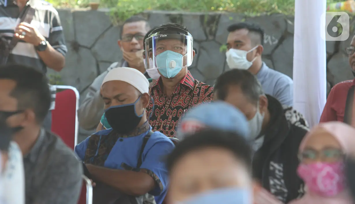 Warga mengantre untuk pembuatan dan memperpanjang SIM di mobil layanan SIM Keliling Masjid At-Tin TMII, Jakarta Timur, Kamis (4/6/2020). Direktorat Lalu Lintas Polda Metro Jaya mengoperasikan kembali layanan mobil SIM Keliling untuk mengantisipasi antrean pemohon. (Liputan6.com/Herman Zakharia)