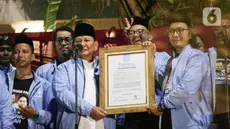 Calon presiden nomor urut dua Prabowo Subianto (kedua kiri) menerima piagam deklarasi dari Panglima relawan Matahari Pagi Setiabudi saat menerima deklarasi dukungan Matahari Pagi di Jakarta, Sabtu (18/11/2023). (Liputan6.com/Faizal Fanani)