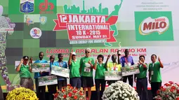 Wagub DKI Djarot Saiful (kelima kiri) dan juara Jakarta International 10K 2015 kategori elit internasional putra, Silas Kiputro (ketiga kanan) berfoto bersama seusai penyerahan hadiah di Silang Monas,  Jakarta, Minggu (31/5). (Liputan6.com/Helmi Afandi)