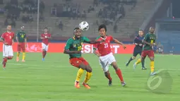 Pemain tengah Timnas Indonesia, Bayu Gatra Sanggiawan berebut bola dengan pemain Kamerun Kombi Mandjang pada laga uji coba di Stadion Gelora Delta Sidoarjo, Rabu (25/3/2015). Kamerun Menang 1-0 atas Indonesia. (Liputan6.com/Herman Zakharia)