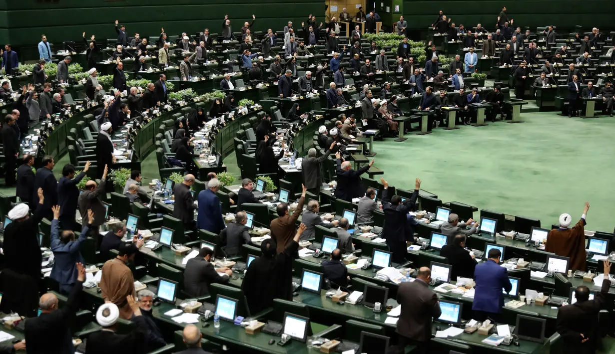 Anggota parlemen Iran mengangkat tangan saat voting RUU yang menetapkan pasukan militer Amerika Serikat sebagai teroris, Teheran, Selasa (7/1/2020). Mosi tersebut telah ditandatangani oleh anggota dewan pimpinan parlemen dan Komisi Integrasi Anggaran. (AP Photo/Vahid Salemi)