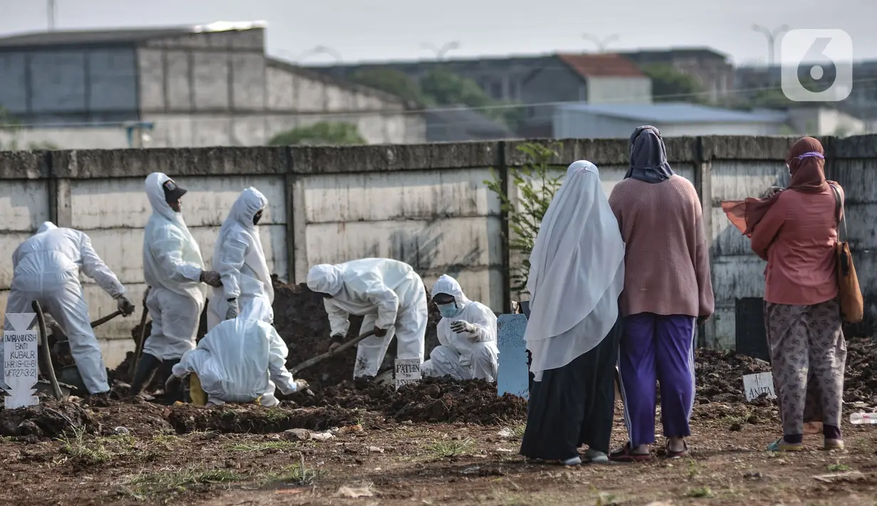 Keluarga saat menyaksikan pemakaman dengan protokol Covid-19 di TPU Rorotan, Jakarta, Minggu (28/3/2021).  TPU Rorotan mulai difungsikan sebagai tempat pemakaman jenazah pasien Covid-19 ber-KTP DKI Jakarta sejak Jumat (26/3) kemarin. (merdeka.com/Iqbal S. Nugroho)