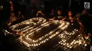 Sejumlah warga menyalakan lilin berbentuk 60+ pada peringatan Earth Hour 2018 di Jakarta, Sabtu (24/3). Sebanyak 7 ikon kota Jakarta ikut serta dalam peringatan Earth Hour. (Liputan6.com/Johan Tallo)