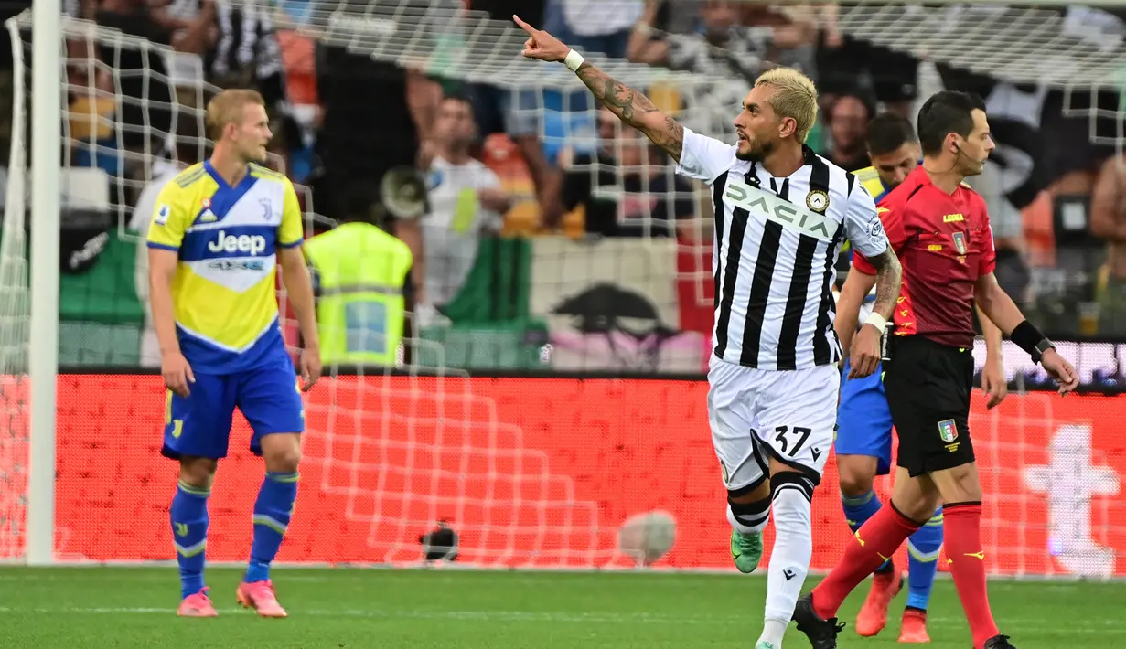 Pemain Udinese Roberto Pereyra merayakan setelah mencetak gol penalti ke gawang Juventus pada pertandingan Liga Italia Serie A di Dacia Arena Stadium, Udine, Italia, 22 Agustus 2021. Pertandingan berakhir dengan skor 2-2. (MIGUEL MEDINA/AFP)