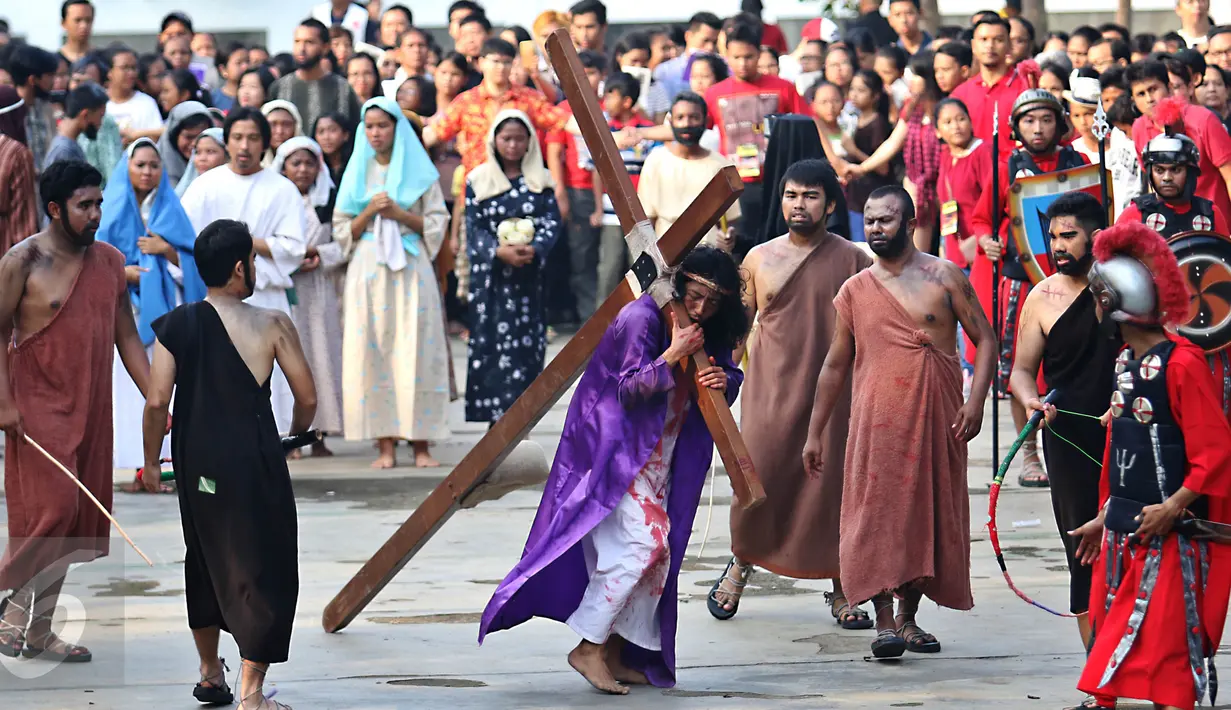 Adegan yang menceritakan Yesus sedang mambawa salib dalam peragaan drama teatrikal Jalan Salib (Tablo) saat perayaan Paskah di Gereja St Matius Penginjil Bintaro, Jumat (14/4). (Liputan6.com/Angga Yuniar)