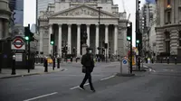 Seorang pria menyeberang jalan pada pagi pertama penerapan lockdown nasional ketiga di Kota London, Inggris, 5 Januari 2021. Inggris memasuki lockdown nasional ketiga sejak pandemi virus corona COVID-19 dimulai. (AP Photo/Matt Dunham)