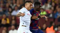 Bek Sevilla Diego Carlos berebut boa dengan winger Barcelona, Ousmane Dembele dalam pertandingan pekan kedelapan kompetisi La Liga Spanyol 2019-2020 di Camp Nou, Minggu (6/10/2019). Barcelona berhasil menang telak atas Sevilla dengan skor 4-0. (Josep LAGO / AFP)