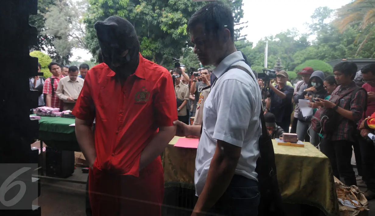 Tersangka pemalsu obat diamankan Ditreskrimsus Polda Metro Jaya, Jakarta, Senin (9/11/2015). Polda Metro Jaya mengamankan 25 jenis obat palsu dan menahan satu orang tersangka. (Liputan6.com/Helmi Fithriansyah)