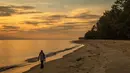 Tengku Mohamad Ali Mansor berjalan menyusuri pantai saat matahari terbit saat dia mencari botol kaca di desa Mangkuk di distrik Setiu negara bagian Terengganu Malaysia timur pada 12 September 2020.  (AFP/Mohd Rasfan)