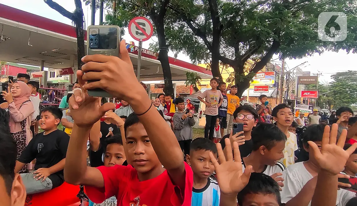 Kerumunan anak-anak di pinggiran jalan menunggu bus melintas membunyikan klakson. (Liputan6.com/Angga Yuniar)