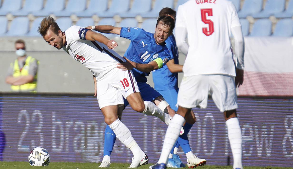 Penyerang Inggris, Harry Kane, berebut bola dengan pemain Islandia, Kari Arnason, pada laga UEFA Nations League di Stadion Laugardalsvollur, Minggu (6/9/2020). Inggris menang tipis dengan skor 1-0. (AP/Brynjar Gunnarson)