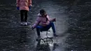 Seorang anak bermanuver di atas kereta luncur yang dibuat khusus saat bermain di sungai yang membeku dekat area perumahan, Beijing, China, 3 Januari 2022. Libur Tahun Baru dimanfaatkan warga untuk bermain ice skating di sungai dan danau yang membeku. (AP Photo/Andy Wong)