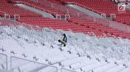 Pekerja membersihkan tempat duduk penonton di Stadion Gelora Bung Karno, Jakarta, Jumat (12/1). Rencananya, Stadion GBK akan diresmikan penggunaannya pasca renovasi oleh Presiden Joko Widodo, Minggu (14/1). (Liputan6.com/Helmi Fithriansyah)