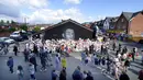 Orang-orang berkumpul menjelang demonstrasi yang direncanakan untuk mendukung pemain sepak bola Manchester United dan Inggris Marcus Rashford, di depan mural yang menggambarkan pemain sepak bola di dinding Coffee House Cafe di Withington, Inggris, Selasa (13/7/2021). (AP Photo/Jon Super)