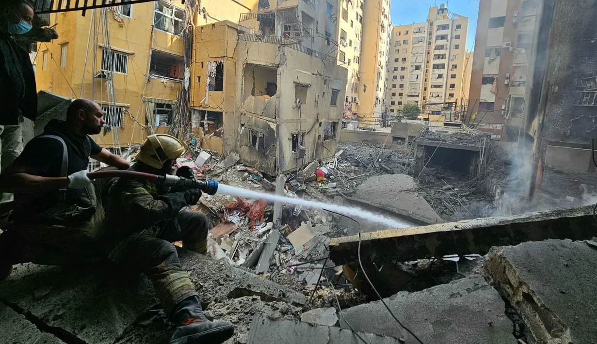 Petugas pemadam kebakaran berupaya memadamkan api di sebuah bangunan setelah serangan udara Israel di distrik Haret Hreik di pinggiran selatan Beirut pada 16 November 2024. (Foto oleh AFP)