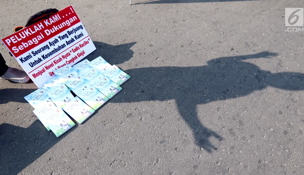 Sejumlah buku berjudul Gadis Kecilku dijual untuk biaya cuci darah dan cangkok ginjal saat Aksi Peduli Viara di kawasan Bundaran HI, Jakarta, Minggu (10/09). Aksi memasuki minggu ke 5 saat Car Free Day. (Liputan6.com/Fery Pradolo)