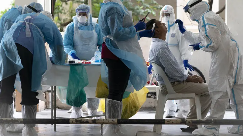 Staf kementerian kesehatan mengumpulkan sampel untuk pengujian virus corona dari seorang penduduk di daerah perkotaan di Bandar Utama, pinggiran Kuala Lumpur, Malaysia pada hari Kamis, 22 Oktober.