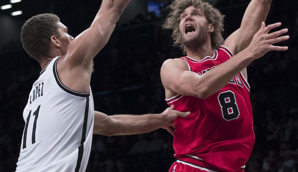 Chicago Bulls center, Robin Lopez #8 berusaha melewati hadangan Brooklyn Nets center, Brook Lopez #11 pada laga NBA basketball game, (31/10/2016) Bulls menang 118-88. (AP/Mary Altaffer)