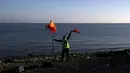 Seorang relawan memberikan tanda kepada Puluhan imigran dan Pengungsi dari Suriah di pulau Lesbos, Yunani, Senin (9/11). Sejak tahun 2015 lebih dari 590.000 imigran menyeberang ke Yunani akibat perang yang terjadi di Suriah. (REUTERS/Alkis Konstantinidis)