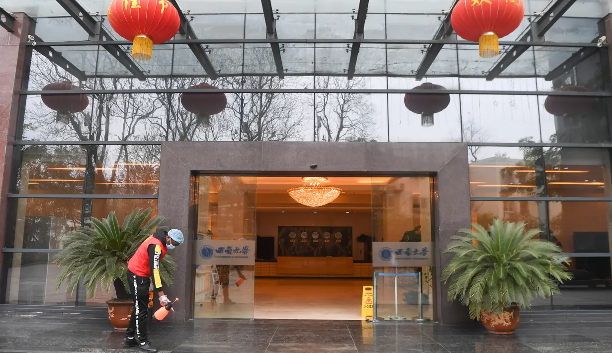 Seorang pelajar asing menyemprotkan cairan disinfektan ke pintu masuk asrama di Universitas Barat Daya di Chongqing, China, 18 Februari 2020. Sejumlah pelajar asing di Chongqing ambil bagian dalam kampanye pengendalian epidemi dengan terlibat dalam pekerjaan sukarela. (Xinhua/Wang Quanchao)