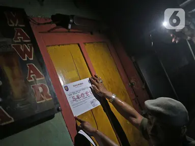 Petugas menyegel salah satu warung remang-remang di gang royal kawasan Penjaringan, Jakarta, Senin (10/2/2020). Pemkot Jakarta Utara bersama instansi terkait, melakukan penyegelan bangunan dan Penertiban Pemakaian Tenaga Listrik (P2TL) di kawasan Gang Royal. (Liputan6.com/Herman Zakharia)