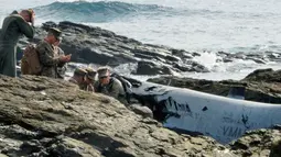 Militer AS berada di dekat puing pesawat Korps Marinir AS MV-22 Osprey usai jatuh di lepas pantai Nago, Okinawa, Jepang, (14/12). Beruntung semua awak selamat dan hanya mengalami luka-luka. (Reuters/Kyodo)