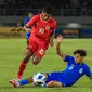 Striker Timnas Indonesia U-16, Fadly Alberto berusaha melewati adangan bek Singapura, Muhammad Luth Harith pada laga matchday pertama Grup A Piala AFF U-16 2024 di Stadion Manahan, Solo, Jumat (21/6/2024). (Bola.com/Radifa Arsa)