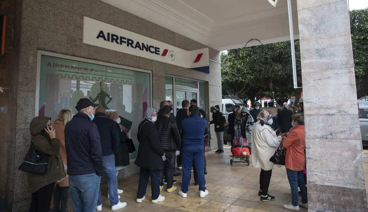 Orang-orang antre di depan kantor Air France untuk membeli tiket penerbangan evakuasi saat perbatasan ditutup akibat varian Omicron, di Rabat, Maroko, Senin (29/11/2021). Maroko menangguhkan semua penerbangan internasional mulai Senin tengah malam selama dua minggu. (AP Photo/Mosa'ab Elshamy)