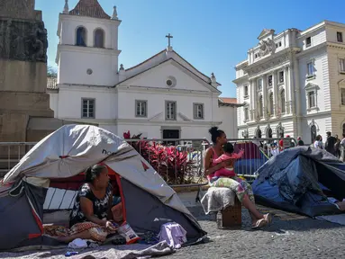 Sebuah keluarga tunawisma terlihat di tenda-tenda yang didirikan di Patio do Colegio, pusat kota Sao Paulo, Brasil, pada 19 Agustus 2021. Sao Paulo menghadapi krisis tunawisma, karena harga baru-baru ini menjadi beban yang terlalu berat bagi populasi yang semakin miskin. (NELSON ALMEIDA / AFP)