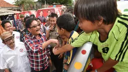 Cawagub DKI Jakarta Djarot Saiful Hidayat menyapa anak-anak yang sedang naik odong-odong saat blusukan ke pemukiman padat Kedoya, Jakarta Barat, Selasa (1/11). Pada kesempatan itu, Djarot mendengarkan keluh kesah warga. (Liputan6.com/Yoppy Renato)