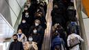 Orang-orang yang memakai masker menggunakan eskalator di distrik Shibuya di Tokyo (19/1/2022). Pemerintah Jepang menyetujui pembatasan virus corona baru di sebagian besar negara, termasuk ibu kota untuk memerangi rekor infeksi yang dipicu oleh varian Omicron. (AFP/Behrouz Mehri)