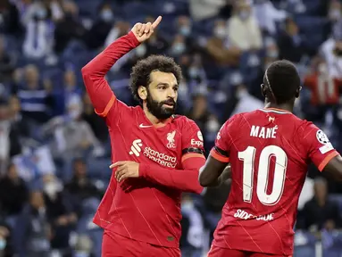 Penyerang Liverpool, Mohamed Salah (kiri) berselebrasi dengan Sadio Mane usai mencetak gol ke gawang Porto pada pertandingan grup B Liga Champions di stadion Dragao di Porto, Portugal, Rabu (29/9/2021). Salah mencetak dua gol dan Liverpool menang telak atas Porto 5-1. (AP Photo/Luis) Vieira)