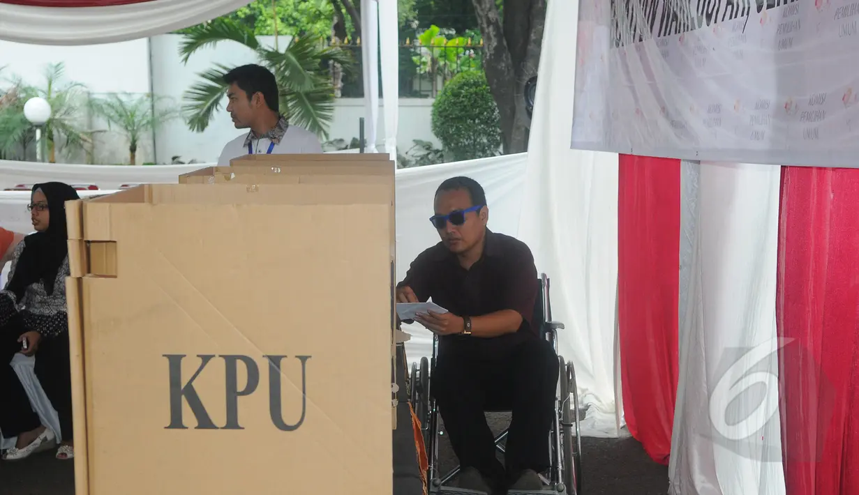 Seorang petugas saat akan mencoblos di bilik suara pada simulasi pemungutan dan penghitungan suara Pemilihan Gubernur, Bupati, serta Walikota di TPS Halaman Gedung KPU RI, Jakarta, Selasa (7/4/2015). (Liputan6.com/Herman Zakharia)