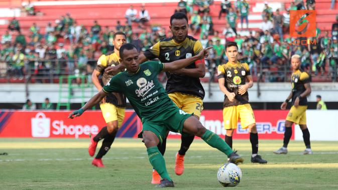 Duel dua pemain sayap, Irfan Jaya (hijau) dan Rizki Pora (hitam), dalam laga antara Persebaya Surabaya kontra Barito Putera di laga tunda pekan keempat Shopee Liga 1 2019 di Stadion Gelora Bung Tomo, Surabaya, Selasa (9/7/2019). (Bola.com/Aditya Wany)