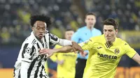 Gelandang Juventus, Juan Cuadrado berebut bola dengan pemain Villarreal, Pau Torres pada pertandingan leg pertama Liga Champions di Estadio de la Ceramica, Spanyol, Rabu (23/2/2022).  Juventus bermain imbang atas Villarreal 1-1.  (AP Photo/Alberto Saiz)