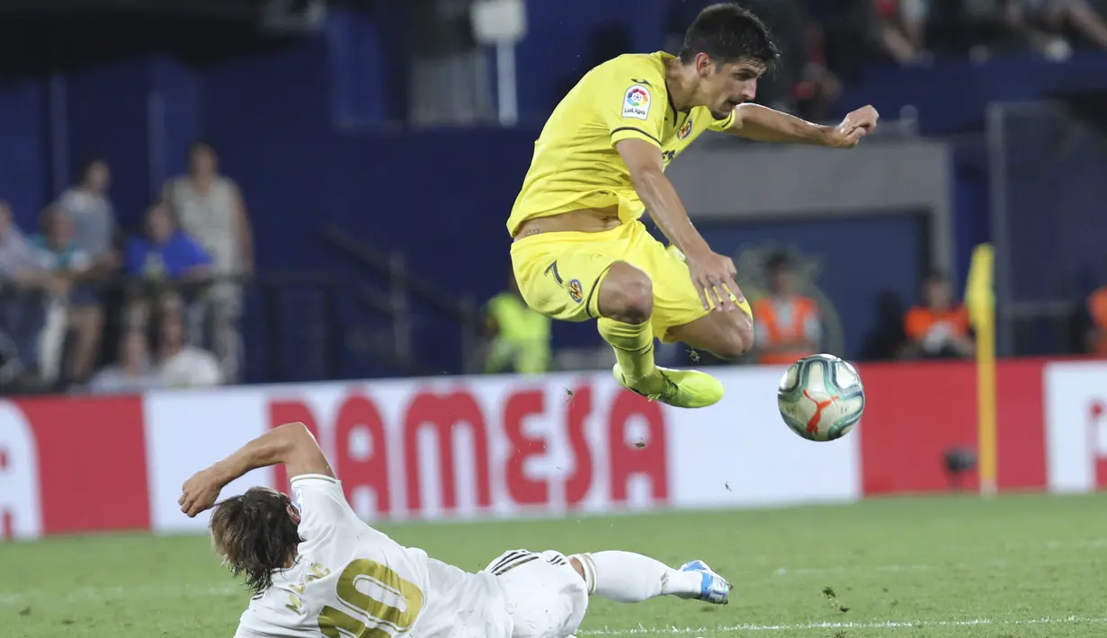Pemain Villareal, Gerard Moreno melewati gelandang Real Madrid, Luka Modric selama pertandingan La Liga Spanyol di stadion Ceramica (1/9/2019). Real Madrid bermain imbang 2-2 atas Villareal. (AP Photo/Alberto Saiz)