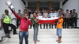 Petugas kepolisian mengamati aksi nelayan yang membawa miniatur kapal ke PTTUN di Cikini, Jakarta, Selasa (30/8). Para nelayan meminta hakim PTTUN menolak banding penerbitan izin reklamasi pulau G. (Liputan6.com/Immanuel Antonius)