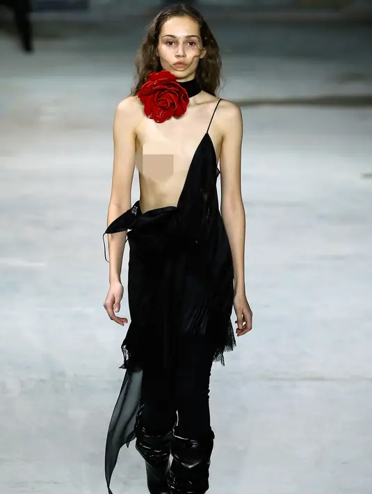 Seorang model mengenakan gaunnya yang melorot saat berjalan di catwalk peragaan busana Yves Saint Laurent ready-to-wear di Paris, 28 Februari 2017. Gaun model tersebut melorot saat menampilkan koleksi Fall-Winter 2017-2018. (AP/Francois Mori)