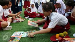 Seorang murid sekolah dasar memilih buku di halaman Istana, Jakarta, Rabu (17/8). Sebanyak 500 pelajar menikmati membaca dan mendengarkan dongeng di halaman istana untuk memperingati Hari Buku Nasional. (Liputan6.com/Angga Yuniar)