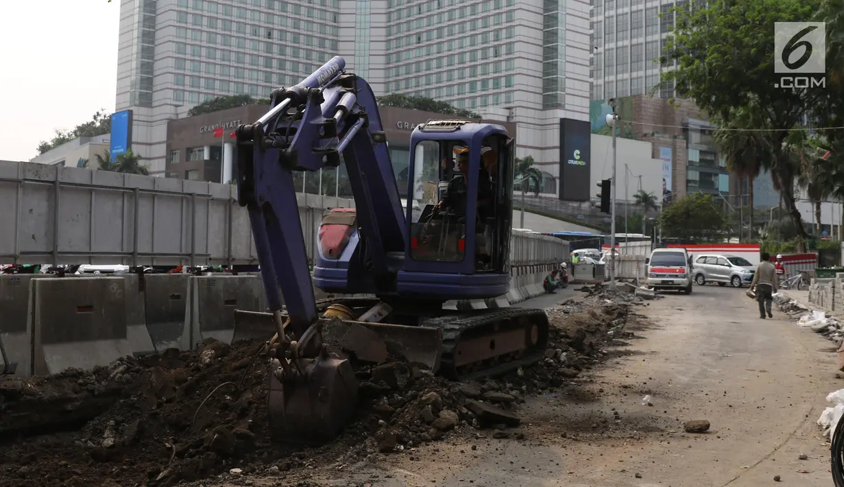 Pekerja dibantu alat berat mengerjakan proyek revitalisasi trotoar di kawasan Bundaran Hotel Indonesia, Jakarta, Selasa (24/9/2019). Pemprov DKI tengah mengebut pembangunan revitalisasi trotoar di sejumlah titik Ibu Kota yang ditargetkan rampung akhir 2019 mendatang. (Liputan6.com/Angga Yuniar)